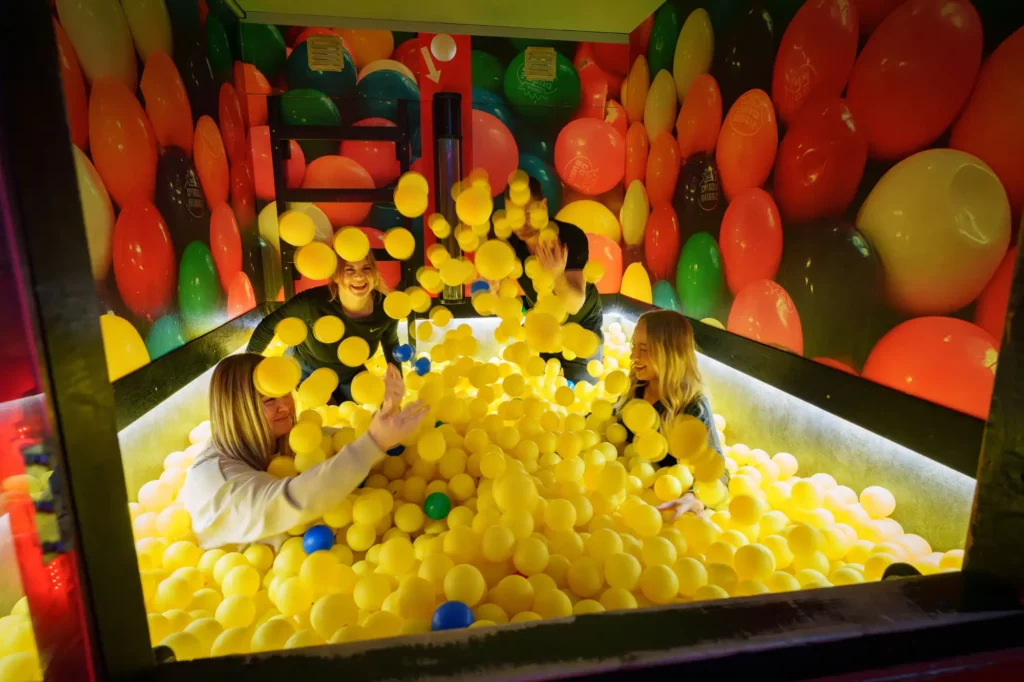 Personer som leker i ett bollhav så bollar sprutar.